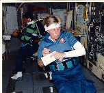 Image of a crew member checks her own vital signs using the wrist display on the AFS-2