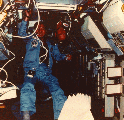Image of two crew member working in the space shuttle in an AFS-2 suit.