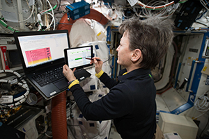 Image of an astronaut using NASA's Playbook tool to schedule her mission activities.